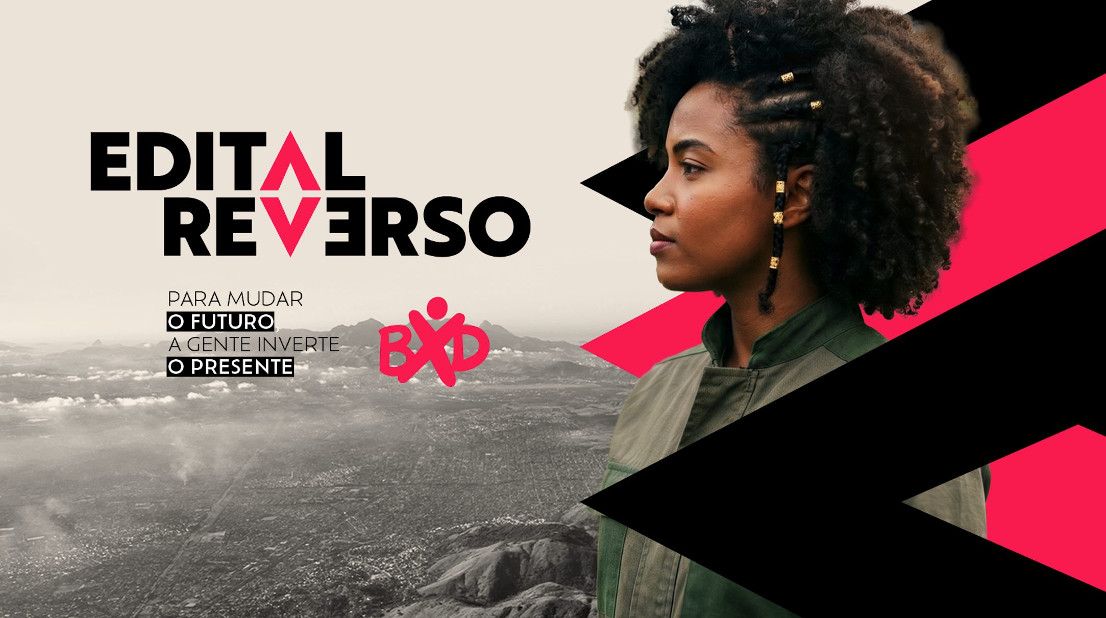 Edital Reverso — Para mudar o futuro, a gente inverte o presente. Mulher jovem negra observa a Baixada Fluminense do alto, com os triângulos da marca em rosa e preto.